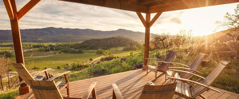 Golden hour sunlight hits the gorgeous Reverie II patio overlooking the vineyards and mountains | Best Wineries in Calistoga