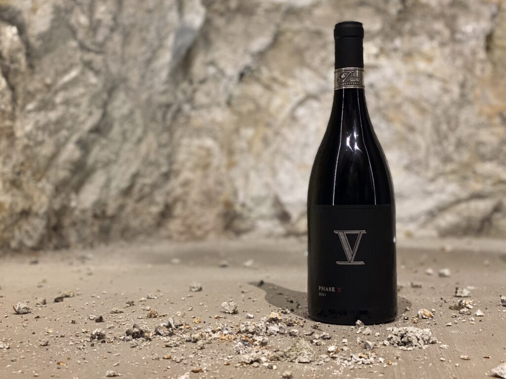Phase V wine bottle on stone floor with rocky background