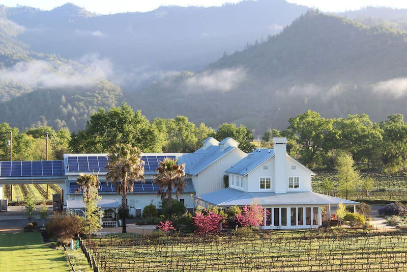 Winery estate with solar panels and vineyard backdrop
