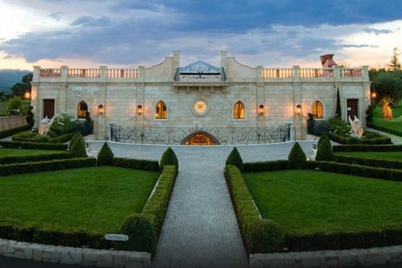 Grand winery estate with manicured gardens at sunset