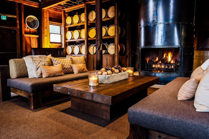 Cozy lounge at Davis Estates with fireplace and wine barrels