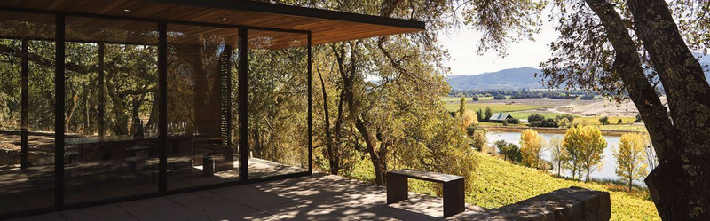 Modern glass winery building with vineyard valley view