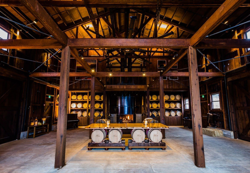 Rustic winery barrel room with wooden beams and warm lighting