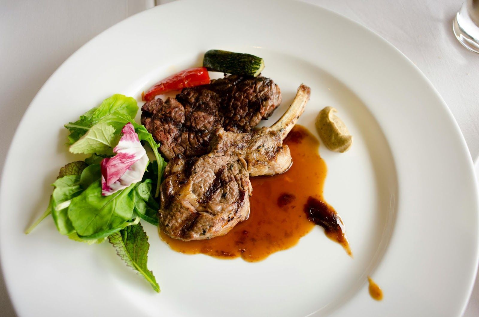 Grilled lamb chops with sauce and fresh greens