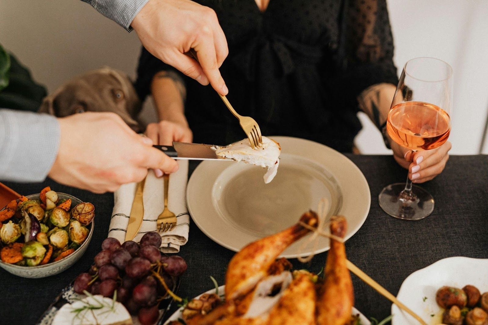 Couple sharing roast chicken dinner with rosé wine